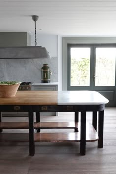 a kitchen with an island table in the middle and a potted plant on top