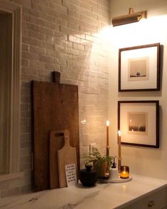 a kitchen counter with candles and pictures on the wall