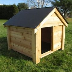 a wooden dog house with a black roof