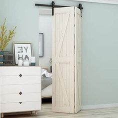 a white dresser sitting next to a sliding door in a room with light blue walls