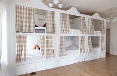 there are bunk beds in the room with curtains on each side and one person laying down