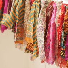 colorful scarves are hanging on a rack