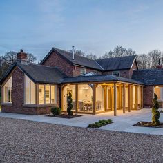 a large brick house with lots of windows on the front and side of it at night