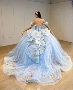 Turn your quinceanera into a magical celebration with this stunning Sky Blue Off-the-Shoulder Quinceañera Dress. This dress features a regal ball gown silhouette and flows gracefully into a dramatic chapel train, making every step feel like a fairy tale moment. The delicate off-the-shoulder neckline highlights your shoulders with elegance, while the sleeveless design ensures comfort throughout your special day. It is made from soft tulle fabric and is adorned with intricate appliques and shimmer Light Blue With Gold Quinceanera Dresses, Sweet 15 Dresses Quinceanera Light Blue, Blue And White Quinceanera Dresses, Quinceanera Dresses Baby Blue, Quinceanera Light Blue, Cinderella Quinceanera Dresses, Sweet 15 Dresses Quinceanera, Baby Blue Quinceanera Dresses, Quinceañera Themes