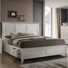 a white bed sitting in a bedroom next to a dresser with drawers on top of it