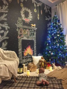 a baby is laying on the floor in front of a christmas tree and fireplace decorated with lights