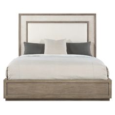 a bed with two pillows on top of it and a headboard made out of wood