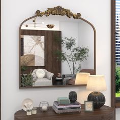 a mirror sitting on top of a wooden table next to a lamp and vases