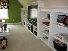 a living room filled with furniture and a flat screen tv sitting on top of a white book shelf