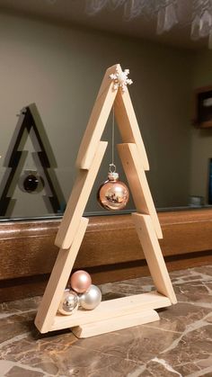 a wooden christmas tree with ornaments hanging from it