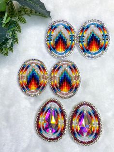 four pieces of colorful beaded jewelry on a white surface