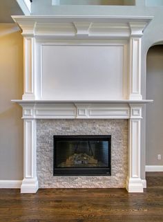 an empty fireplace in a living room with wood flooring and white painted mantles