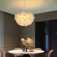 a dining room table with chairs and a light fixture hanging from the ceiling above it