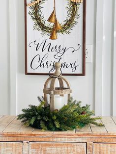 a christmas sign hanging on the side of a wooden cabinet next to a candle holder