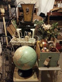 an old world globe sits on top of several boxes and other items in a room