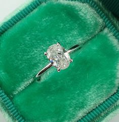 an engagement ring in a green velvet box