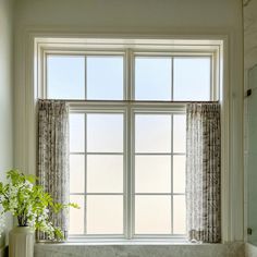 a bathroom with a tub, sink and large window