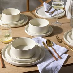 the table is set with white dishes and silverware