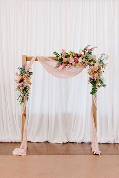 a wedding arch decorated with flowers and greenery