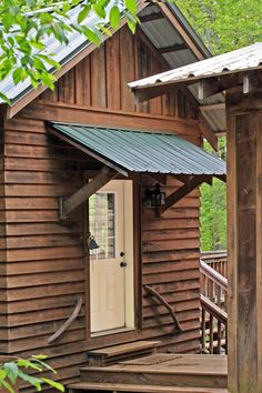 a small wooden cabin with a door and porch