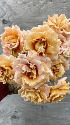 a bunch of flowers sitting on top of a wooden table