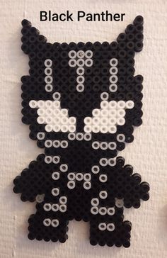 a black and white cat made out of legos on a table with the words black panther written below it