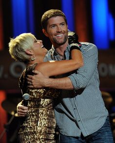 a man and woman hugging each other on stage