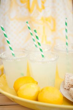 lemonade and rice krispy treats on a yellow plate with green striped straws