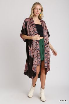 The Satin Breeze Border Print Kimono is an elegant and lightweight layering piece that adds a touch of sophistication to any outfit. Crafted from 100% polyester, this kimono features a smooth, silky satin finish that drapes beautifully over the body. The open front design allows for effortless styling, while the intricate border print adds a touch of artistry and visual interest. Short sleeves make it perfect for warmer weather, and the flowy silhouette enhances its relaxed, bohemian vibe. Fit & Bohemian Black Printed Kimono, Black Bohemian Kimono With Kimono Sleeves, Summer Black Silk Kimono, Black Silk Summer Kimono, Black Silk Kimono For Summer, Black Flowy Bohemian Kimono, Beach Kimono With Satin Material, Flowy Black Kimono For Vacation, Beach Kimono With Satin Material And Kimono Sleeves