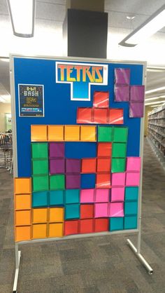 a bulletin board with colorful blocks on it in an office building or school library area