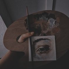 a person is holding a pencil and drawing on a piece of paper with an eye drawn on it