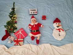 a baby dressed as santa claus and other christmas decorations