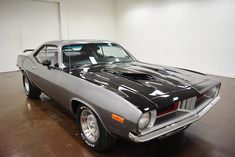 an old muscle car parked in a garage