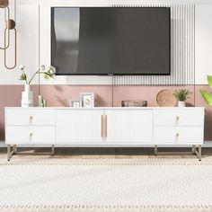 a large flat screen tv mounted to the side of a white cabinet in a living room