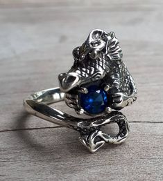 dragon ring sterling silver Blue cubic zircon It weights 8-9 gms (depending on the size) She measures 25mm (1 '')from top of his head to his tail IF your size is not listed pls convo me I CAN MAKE HIM WITH ANY STONE.. FOR ANY SIZE FINGER I have this one listed in 9ct gold also