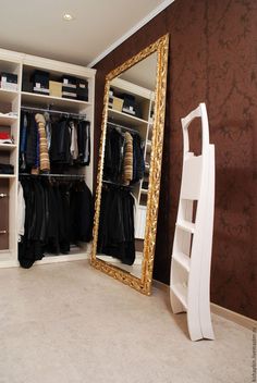 a large mirror sitting next to a closet filled with clothes