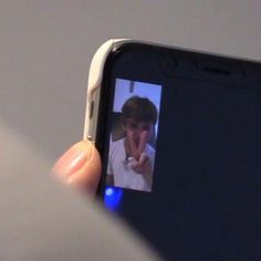 someone is holding up their cell phone to take a selfie with the image on it