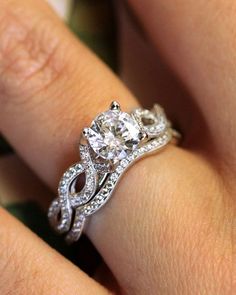 a woman's hand with a diamond ring on top of her finger and an engagement band