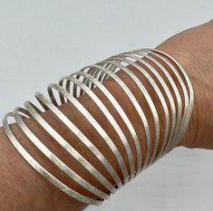 This statement making metal cuff bracelet offers a modern design with geometric features and a monotone color scheme, making it simple to use. It's the perfect addition to any outfit where a bold touch is required, and is sure to stand out in any crowd. This is an attention grabbing piece that adds shine to any outfit. Metal strips that cross the arm are connected by two bands on either side for a modern versatile look. We have a handful of two options, either brass or silver plated brass. Detai Statement Cuff Bracelet, Multiple Rings, Metal Cuff Bracelet, Drama Queen, Metal Bracelet, Silver Cuff Bracelet, Metal Bracelets, Color Scheme, Cuff Bracelet