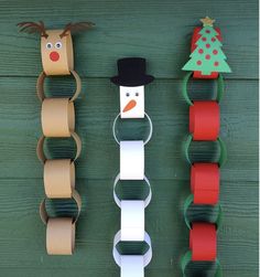 toilet paper roll christmas decorations hanging on a green door with snowman, reindeer and tree