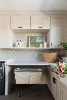 a washer and dryer in a small room with white cabinets on the wall