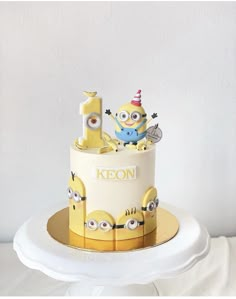 a yellow and white cake decorated with minion characters