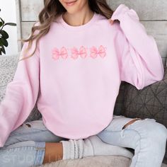 Order by December 9th, to help ensure delivery via USPS by 12/24. 📦 Elevate your style with our coquette-style crewneck sweatshirt, featuring watercolor-style pink bows that add a touch of whimsy and elegance to your wardrobe. Perfect for those who embrace playful sophistication, this sweatshirt makes a statement without saying a word. * PRODUCT DETAILS - Unisex Sweatshirt - Printed with ink - Ribbed knit collar, retains its shape even after washing. - No itchy side seams - 50% cotton, 50% poly Cute Pink Crew Neck Sweatshirt, Casual Crew Neck Top With Pink Bow, Crew Neck Cotton Top With Pink Bow, Cotton Crew Neck Top With Pink Bow, Princess Energy, Pastel Princess, Aesthetic Crewneck, Style Feminine, Coquette Style