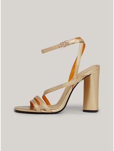 Tommy Hilfiger women's shoe. Revive your night-out shoe collection with these strappy sandals that sit on a chunky block heel and showcase luxe branded hardware.  Material: 100% Leather (fwa). Luxury Block Heels With Stacked Heel For Summer, Luxury Stacked Heel Block Heels For Summer, Spring Gold Leather Block Heels, Spring Leather Gold Block Heels, Luxury Gold Heels With Stacked Heel, Luxury Gold Stacked Heel, Luxury Block Heels For Spring, Luxury Block Heels For Spring Party, Luxury Spring Block Heels For Party