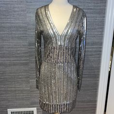 Beautiful Silver Beaded V-Neck, Long Sleeve Mini Dress! Size Medium (Fits 4-6) Has A Little Stretch So It's Very Comfortable And Forgiving. Worn Once And Is In Great Condition- A Few Beads May Be Missing Here And There But Nothing Noticeable Embellished V-neck Dress For Date Night, Embellished V-neck Mini Dress For Night Out, Chic Sequined V-neck Dress For Party Season, Holiday V-neck Embellished Sequin Dress, Embellished Fitted V-neck Mini Dress, Sequin Mini Length V-neck Evening Dress, Spring V-neck Embellished Sequin Dress, Embellished V-neck Evening Mini Dress, Fitted Sequin V-neck Dress