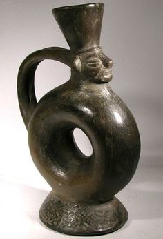 a metal vase with a cat's head sticking out of it