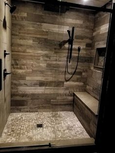 a walk in shower sitting next to a tiled floor and wall with lights on it