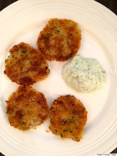 four crab cakes on a white plate with blue dip