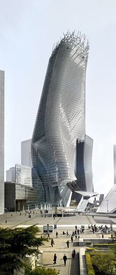 people walking around in front of a building with an unusual structure on it's side