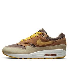 The Nike Air Max 1 Premium 'Ugly Duckling Pecan' is a stylish sneaker that is perfect for everyday wear. It features a brown leather upper with a yellow Swoosh, and a rubber sole for extra traction. The inspiration behind the design comes from the Baroque era, with the layered brown and beige leather covering the midfoot and mudguard. The yellow Swoosh and embroidered duck on the heel complete the look. This sneaker is suitable for a variety of activities, from running errands to going out with friends. (SNKR/Retro/Unisex/Low Top) Brown Boost Midsole Sneakers For Streetwear, Brown Sneakers With Boost Midsole For Streetwear, Brown Suede Sneakers For Streetwear, Brown Sporty Custom Sneakers With Rubber Sole, Urban Brown Sneakers For Streetwear, Brown Urban Sneakers For Streetwear, Brown Low-top Custom Sneakers With Boost Midsole, Nike Brown Suede Sneakers, Brown Sports Sneakers With Rubber Sole